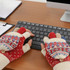 Fingerless gloves in red, white, and beige with a patterned design, resting on a black keyboard.