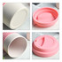 A bamboo fibre coffee cup in white with a pink silicone lid, featuring a smooth interior and a circular base.