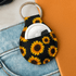 A neoprene keychain featuring a vibrant sunflower design, with a metallic keyring attached.