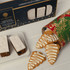 A festive gift pack featuring Christmas cake slices and gingerbread tree cookies, with decorative packaging in red and green.