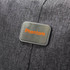 A close-up of a grey fabric with a metallic tag featuring the word "Phantom" in orange. The fabric appears textured.
