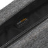 A close-up of a grey fabric bag showing a hidden zip and tag, featuring a logo on the inner lining.