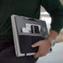A multifunctional clipboard in grey and black, featuring pockets for a phone, pen, and other accessories.