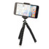 A black Flex Tripod with adjustable legs and a smartphone mounted on top. Features a compact design for easy portability.