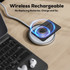 A wireless rechargeable tag rests on a circular charging pad, with a laptop and earbuds nearby. The tag is sleek and black.