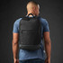 A black laptop backpack is worn on a person's back, featuring a sleek design and a matte finish.