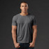A grey crew neck t-shirt for men, featured on a model against a dark background. The shirt has a simple design.