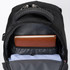 A black backpack with a padded interior, featuring a notebook and a folded shirt inside. It includes a logo.