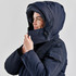 A navy blue women's puffer jacket with a hood, featuring a zip and adjustable collar. It has a logo on the sleeve.