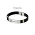 A sleek black bracelet featuring a silver metal buckle latch and engraved logo.