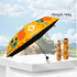 A small lightweight umbrella in vibrant orange with abstract designs, featuring a black underside and a logo.