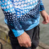 A long sleeve fishing tee featuring a blue and white dot pattern and abstract design, with a visible logo.