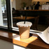 A drink bottle with a black paper straw, sitting on a wooden windowsill in a café setting.