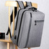 A sleek grey laptop backpack with multiple compartments hanging on a wooden chair. It features a logo on the side.