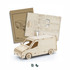 A wooden model van in natural colour, alongside assembly instructions and pre-cut parts for assembly.