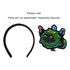 A black felt headband with an attached cartoonish green character design featuring musical notes. Assembly required.