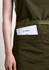 A green apron featuring a front pocket holding a menu card, with a simple logo.