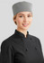 A woman wearing a black chef jacket with black buttons and a checkered chef hat.