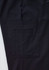 A close-up of black cargo pants featuring a large side pocket and a subtle logo on the waistband.