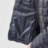 A navy blue women's puffer jacket with an unzipped interior pocket and quilted design. Features a logo on the sleeve.
