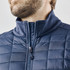 A men's softshell jacket in navy blue with a high collar and quilted texture. Features a zippered front.
