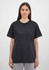 A black women's short sleeve tee is displayed on a model, featuring a simple design and relaxed fit.