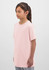A light pink short sleeve tee is displayed on a young girl. The tee has a simple design and a loose fit.