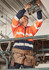 A worker in an orange and navy hi-vis full zip hoodie uses a tool while standing on a scaffold, wearing a hard hat.