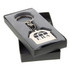 A silver keychain in the shape of a house, presented in a grey box with a logo.