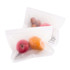 Transparent large storage bags containing red apples, an orange, and some nuts, with a logo on the bag.