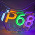 A waterproof IP68 neon LED sign in vibrant colours, partially submerged in water with bubbles. Features a branding logo.