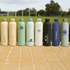 A drink bottle collection featuring various designs and colours, including pale pink, mint green, black, and blue, with branding.