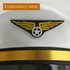 A pilot-themed cap featuring a white fabric base, an embroidered winged emblem, and a black and gold trim.