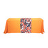 A large table runner featuring a vibrant abstract pattern in red, black, and white on an orange tablecloth.