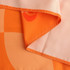 An orange medium table runner with a smooth finish and contrasting lighter edges.