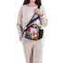 A clear PVC sling bag in black, containing a drink bottle, snacks, and a smartphone. The model is wearing casual attire.