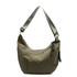 A khaki crossbody bag with a curved design and adjustable strap, featuring a zippered pocket and decorative pull.