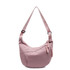 A pink crossbody bag with a curved shape, featuring a braided zipper detail and an adjustable strap.