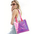 A woman poses with an iridescent clear tote bag featuring pink straps and a beige clasp, against a light background.