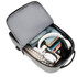 A grey laptop backpack with a USB charging port, packed with headphones, clothing, and various accessories.