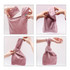A pink Velvet Knot Wrist Bag is being manipulated into different positions, showcasing its flexible design.