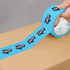 A roll of blue BOPP packaging tape featuring a logo design, partially applied to a cardboard box.