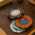 A set of Royal Crown clay poker chips in black, red, and blue, stacked on a wooden surface.