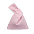 A pink cotton wrist bag with a unique twisted top design. It features a simple, solid colour and a logo.