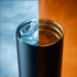 A drink bottle with a matte black finish, featuring ice on one side and steaming liquid on the other, with a handle.