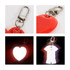 A reflective keychain in the shape of a red heart and a white shirt, featuring a metal clip for attachment.