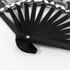 An 8-inch bamboo fabric hand fan with a black wooden frame and decorative fabric design featuring shades of white and black.