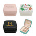 A collection of PU leather jewellery boxes in pink, white with a floral design, black with gold branding, and teal inside.