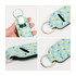 A neoprene lipstick bag featuring a blue background with yellow lemon patterns and a silver keyring attachment.