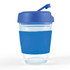 A reusable coffee cup with a transparent body and a blue silicone sleeve and flip lid.
